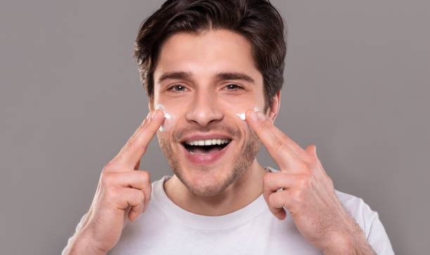 istock Young man applying moisturizer cream on his face 1162770707