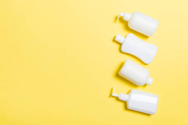 istock Set of White Cosmetic containers isolated on yellow background, top view with copy space. Group of plastic bodycare bottle containers with empty space for you design 1162774120