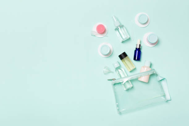 istock Group of small bottles for travelling on blue background. Copy space for your ideas. Flat lay composition of cosmetic products. Top view of cream containers with cotton pads 1162774170