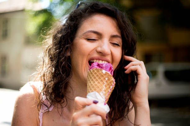 młoda kobieta jedząca lody słoneczny dzień na świeżym powietrzu - sunny cheerful close up outdoors zdjęcia i obrazy z banku zdjęć
