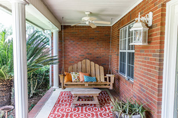 Colorful bohemian outdoor front porch decoration with seating and a plant Colorful and modern bohemian boho outdoor front porch decoration with seating and a plant. The house is red brick and traditional. porch photos stock pictures, royalty-free photos & images