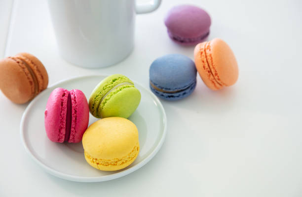 istock Colorful macarons and coffee cup on white background, close up view 1162775998