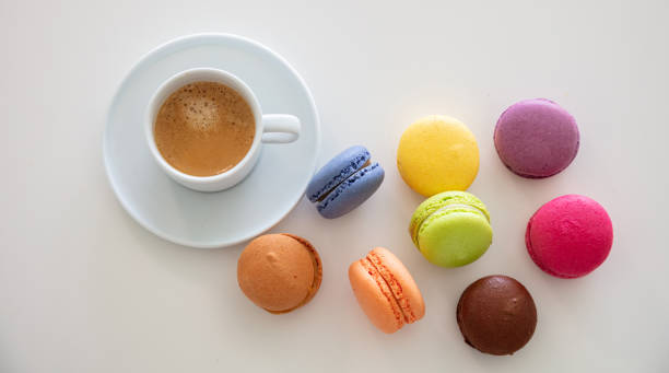 istock Colorful macarons and coffee cup on white background, close up view 1162776003