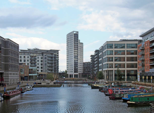 a view of clarence dock in leeds with moored barges and people walking around the surrounding buildings - leeds england yorkshire canal museum imagens e fotografias de stock