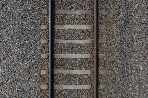 image of railway rails with sleepers on gravel close-up top view