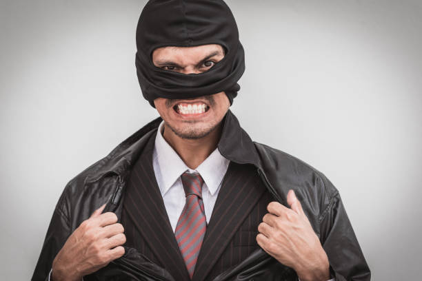 istock Robber in classic businessman pose tearing open shirt 1162785784