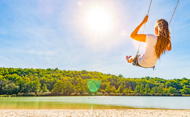 istock Woman on a swing at a lake 1162786050