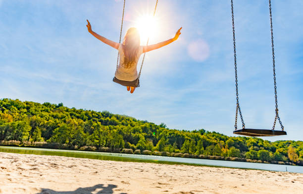 istock Woman on a swing at a lake 1162786062