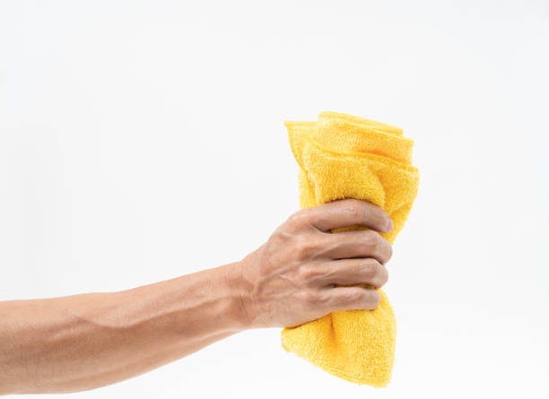 istock Man hand holding yellow rag on white background 1162787688