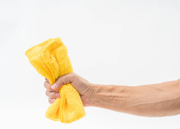 istock Man hand holding yellow rag on white background 1162787837