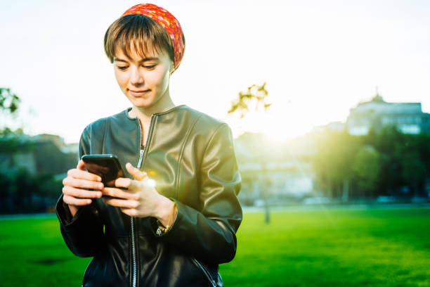 istock Young woman using phone in a park 1162789812