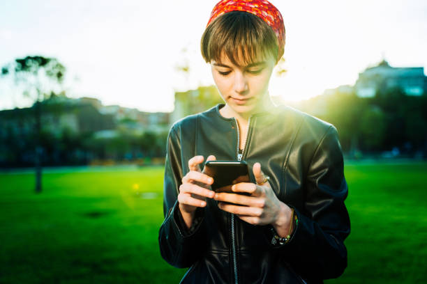 istock Young woman using phone in a park 1162789816