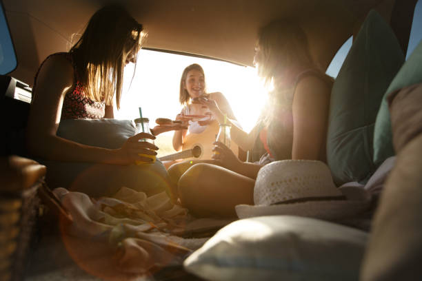istock Group of girlfriends having fun on camping trip in a car 1162792778
