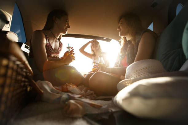 istock Three young females having fun while relaxing and talking on their road trip 1162792791