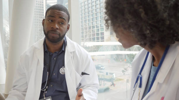 istock Serious male doctor talking with colleague 1162792806