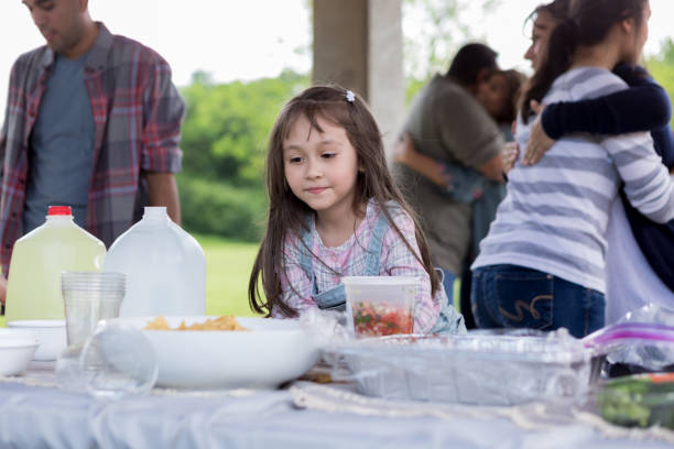 istock Elementary age girl is tempted by picnic food 1162792912