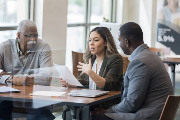 istock Mid adult bank manager explains paperwork for application 1162793174