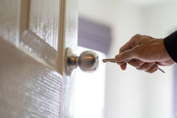 Close-Up Of Keys In Door Hanging From Keys Doorknob At Home