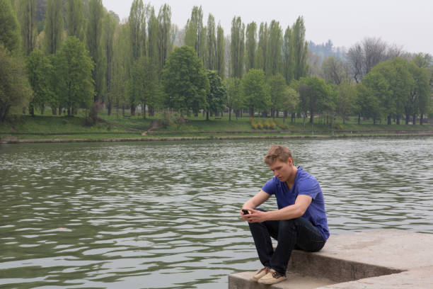 Sad lonely man sitting on a bench alone with flowers, his date didn't show up, isolated on white background