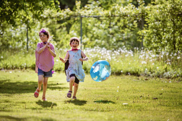 istock Happy kids playing with a balloon earth shape 1162800094