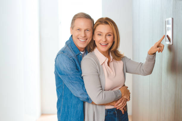 istock smiling husband hugging wife pointing at smart home control panel 1162802538