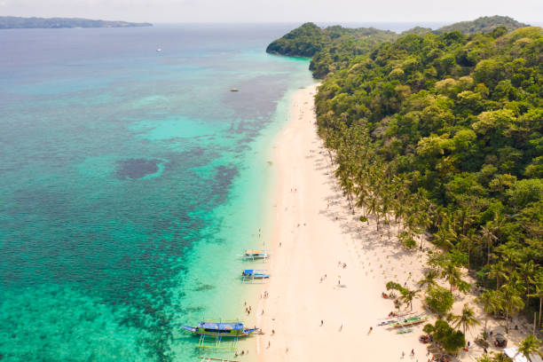 istock Puka Shell Beach. Wide tropical beach with white sand. Beautiful white beach and azure water on Boracay island, Philippines, top view 1162805584