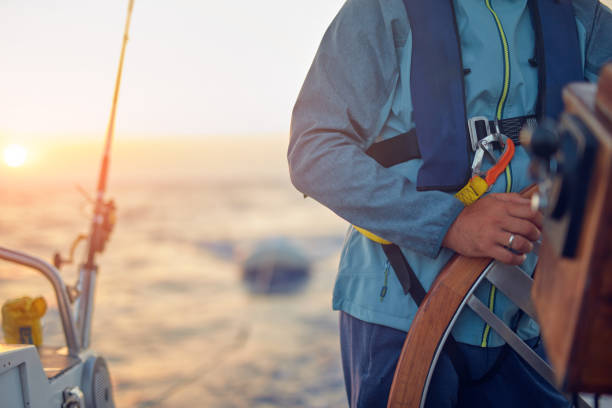 istock Sailor using wheel to steer rudder on a sailing boat. 1162809056