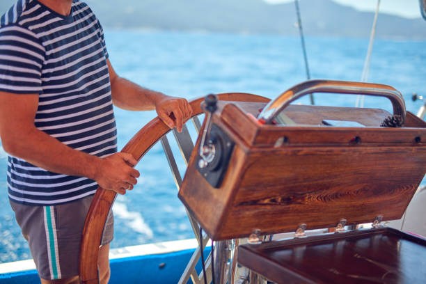 istock Sailor using wheel to steer rudder on a sailing boat. 1162809131