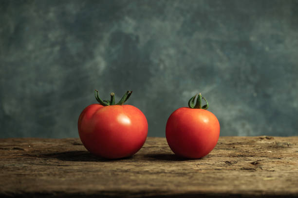 istock Fresh tomatoes on a old oak wooden table, beautiful  gray wall background. 1162809219