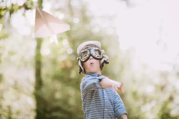 Photo of Cute Little Boy Pretending to Be Pilot With Paper Airplane