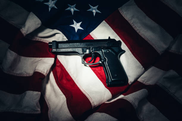 istock Gun Laying on an American Flag in Gun Control Concept 1162810571