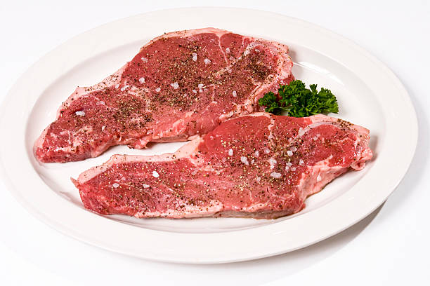 istock Two Raw New York Strip Steaks isolated on white seasoned 116281072