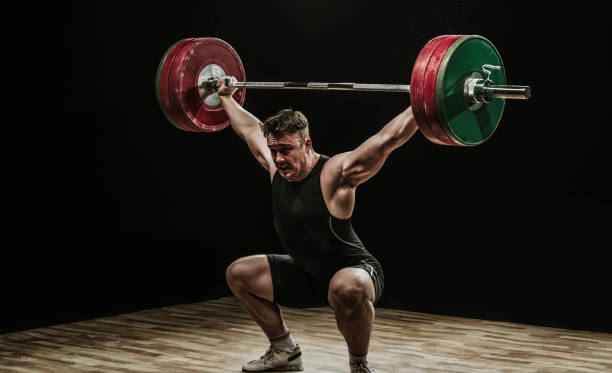 allenamento maschile con bilancieri - crouching barbell weightlifting weight training foto e immagini stock