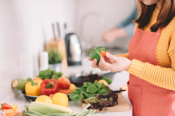 istock young woman cutting vegetables at kitchen 1162810950