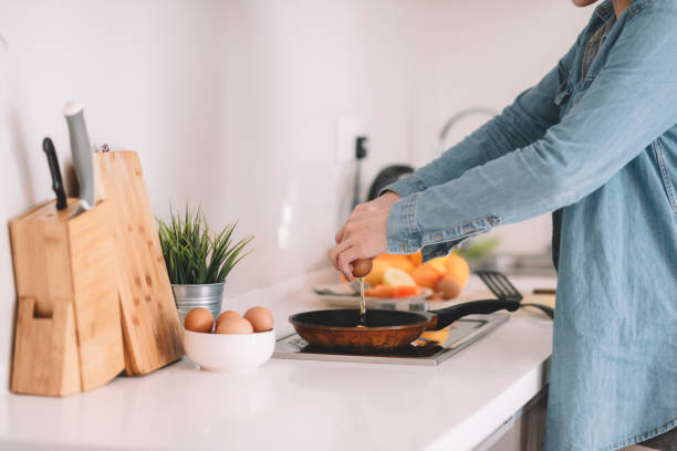 istock young women preparing cooking egg at kitchen smiling 1162811043