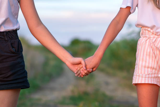 istock young unrecognizable lesbian couple holding hands at sunset outdoors. Lifestyle and pride concept. 1162814218