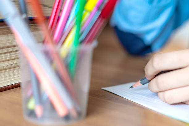 istock schoolgirl doing homework with pencil on paper, back to school comcept 1162814344