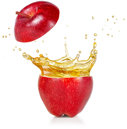 transparent juice squirting out of a red apple isolated on white