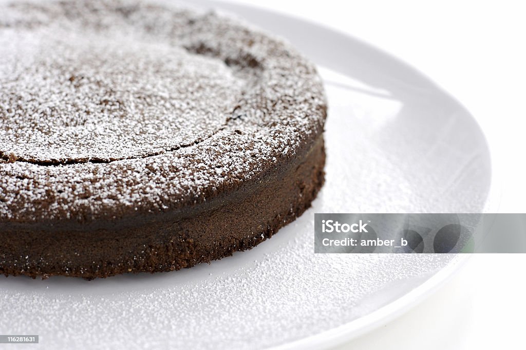 French style chocolate cake in white background Rich and dark French style chocolate cake dusted with icing sugar. Please see the details of sugar on cake and the plate. Shallow dof. Chocolate Cake Stock Photo