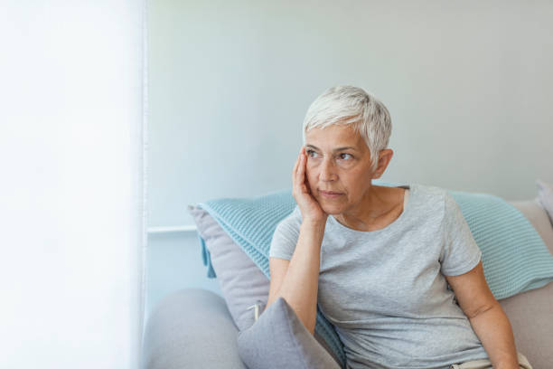 istock Depressed senior woman sitting on sofa at home 1162818642