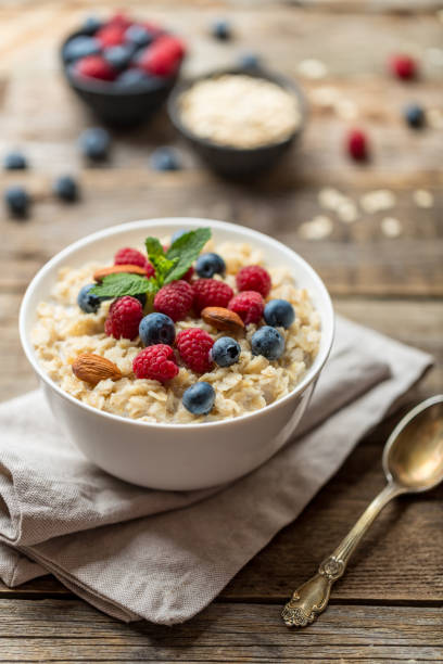 istock Oatmeal with raspberries, almonds and blueberries and mint isolated on white 1162820712