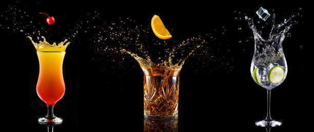 cócteles salpicando sobre fondo negro - cocktail alcohol drink black fotografías e imágenes de stock