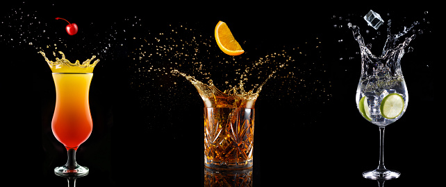 set of cocktail glasses splashing on black background