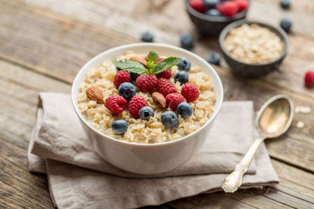 istock Oatmeal with raspberries, almonds and blueberries and mint isolated on white 1162820827