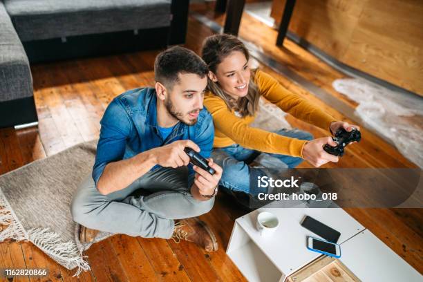 Lächelndes Paar Spielt Videospiele Stockfoto und mehr Bilder von Computerspiel-Konsole - Computerspiel-Konsole, Kaffee - Getränk, Paar - Partnerschaft