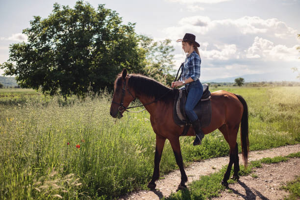 cowgirl a cavallo che si gode la natura - shirt checked women wild west foto e immagini stock