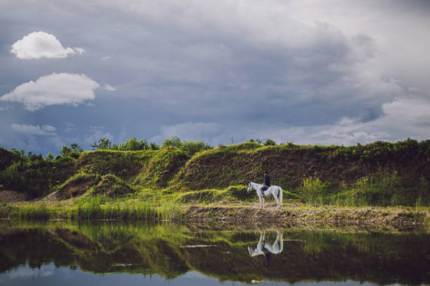 Handsome man with cool attitude enjoying a horseback riding outdoors in nature.