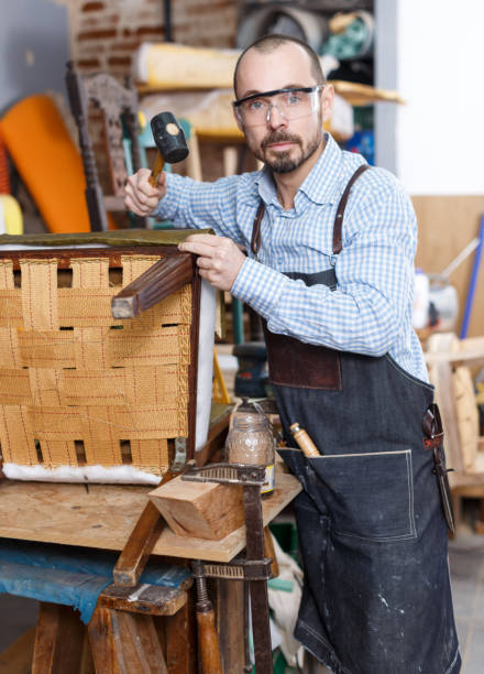 istock Craftsman reupholstering chair in workshop 1162822430