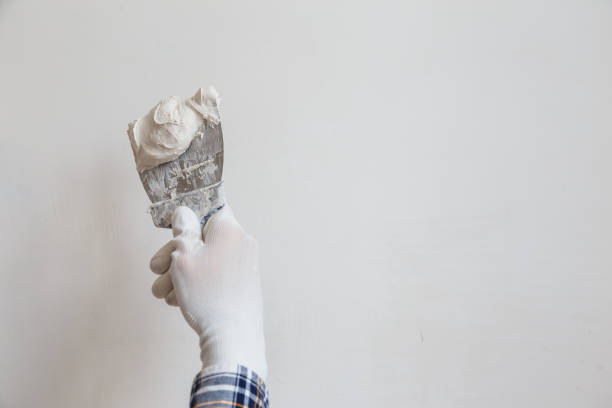 istock Putty the wall gypsum putty with spatulas. 1162823773