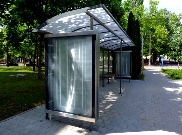 bus shelter at a bus stop of glass and aluminum structure in park like setting stock photo